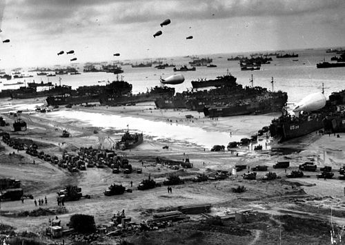 The Allied beachhead in Normandy with landing ships, vehicles and barrage balloons after D-Day.