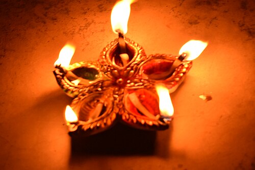 Many small clay oil lamps glowing in the dark